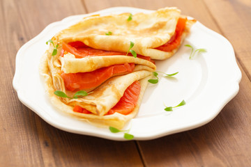 Crepes with smoked salmon on a white plate. Delicious and healthy Breakfast.