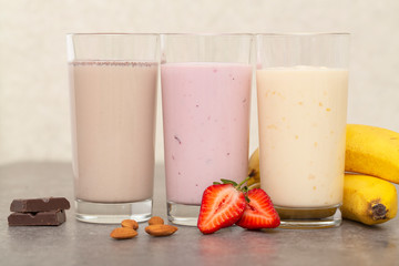 Assorted protein cocktails. Strawberry, banana and chocolate protein shakes. Sports nutrition and healthy lifestyle concept.   
