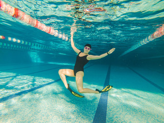 woman swimming in yellow flippers in pool underwater © phpetrunina14