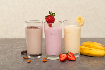 Assorted protein cocktails. Strawberry, banana and chocolate protein shakes. Sports nutrition and healthy lifestyle concept.   