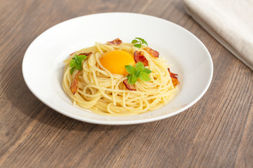 Carbonara pasta, spaghetti with pancetta, egg, hard parmesan cheese, basil and cream sauce. Traditional italian cuisine. 