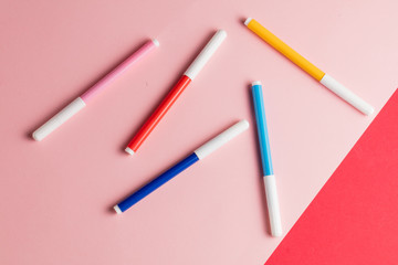 four felt-tip pens isolated on pink and red background. top view photo. cryons for paiting, drawing.