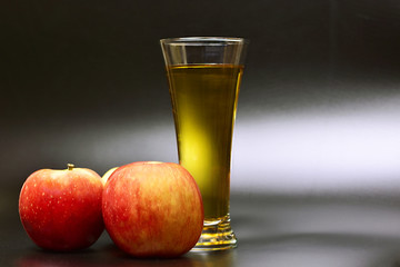 still life with apples and a glass with apple juice