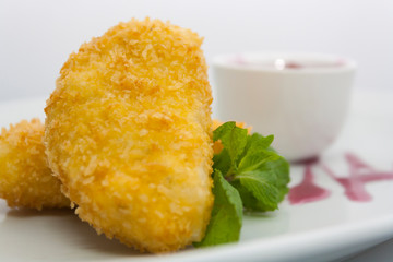 potato patties with grape sauce and mint on a white plate
