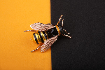 Beautiful brooch in the form of a fly on a yellow background