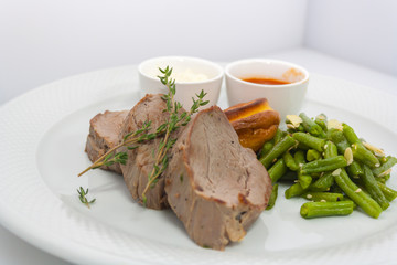 roast beef and yorkshire pudding with baked green beans on white background