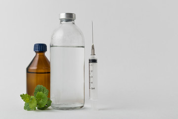 medical drugs and beauty products in glass jars for injections with a syringe with a needle on a white background