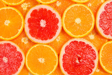 Slices of oranges and a grapefruits as a background.