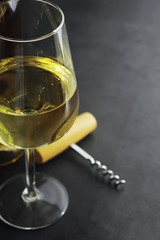Transparent bottle of white dry wine on the table. White wine glass on a wooden background.