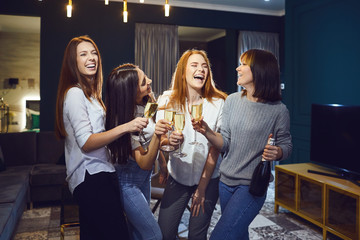 Group of women with glasses of champagne having fun at a party at home.
