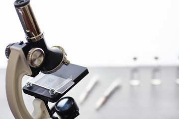 Research laboratory. Test tubes and microscope on the table on a white background.