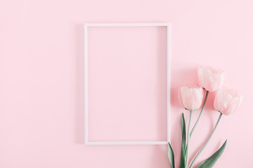 Beautiful composition spring flowers. Blank frame for text, pink tulips flowers on pastel pink background. Valentine's Day, Easter, Birthday, Happy Women's Day. Flat lay, top view, copy space 
