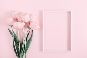 Beautiful composition spring flowers. Blank frame for text, pink tulips flowers on pastel pink background. Valentine's Day, Easter, Birthday, Happy Women's Day. Flat lay, top view, copy space 