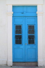 Fototapeta na wymiar Blue front door in white stone wall