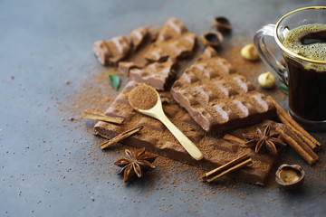 A bar of milk chocolate on the table. Chocolate with nuts and cinnamon.