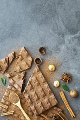 A bar of milk chocolate on the table. Chocolate with nuts and cinnamon.