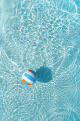Obraz premium Water polo ball in blue pool water. Top view. Copy space.