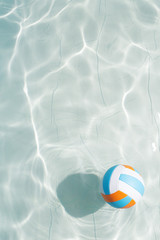 Obraz premium Water polo ball in blue pool water. Top view. Copy space.