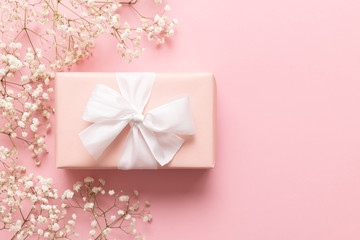 Mother's day card, pink background with white flowers and a present