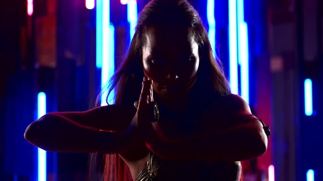 close up. portrait of a girl dancing Oriental dance in neon light