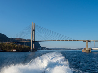 Water wave tail from ferry boat with Nordhordland Bridge in the background, Bergen Norway