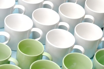A pile of green white coffee mugs on the ground floor at the wholesale market 