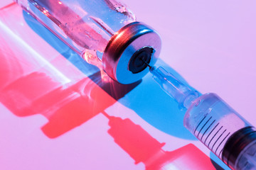 Glass bottle with vaccine and syringe for injection.