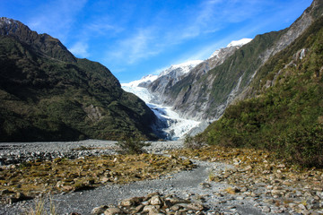 View on the Franz Josef Glacier, rocky climb with some green vegetation on both sides, West Coast of New Zealand's South Island