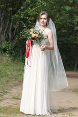 Fototapeta na wymiar Beautiful bride outdoors in a forest.