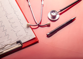 Medical concept. Stethoscope and heart rate cardiogram diagnostic on red background.