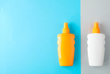 Composition with sunscreen sprays on two tone background. Space for text, top view