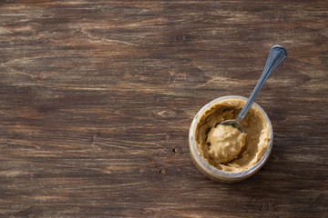 Jar with peanut butter on a wooden table