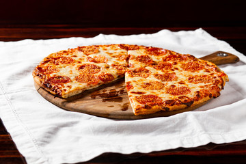 mini pizza on wooden board. small pepperoni pizza