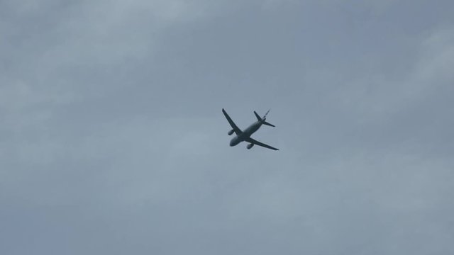 Plane flies overhead on departure through blue sky. Enters and leaves shot.