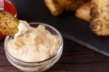 young woman dip fried potatoes to mayonnaise sauce