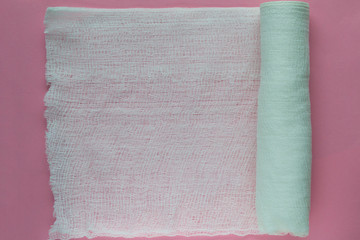Medical bandage on a pink background close-up.