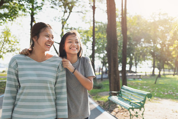 Asian mother and daughter feel relaxed While walking in the park in the morning