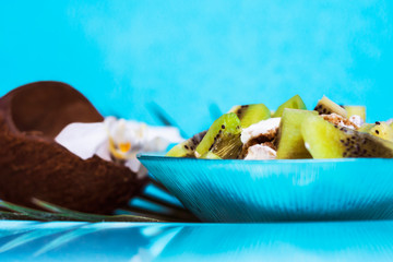  Blue plate with appetizing muesli, yogurt and kiwi slices in th