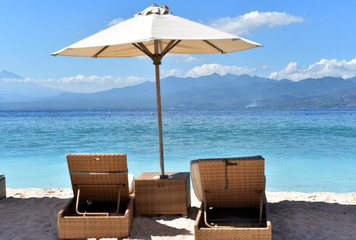 Sun loungers and parasols on a beautiful sandy beach with ocean view, Gili Trawangan Island, Lombok, Indonesia