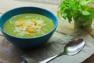 fresh mashed soup with broccoli and green beans in a blue plate on a wooden background