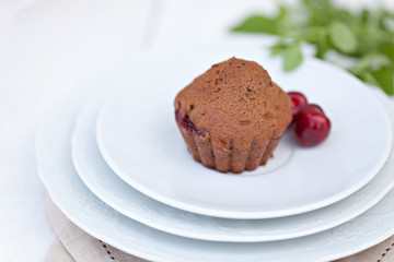 Fototapeta na wymiar Chocolate muffins with ripe cherries