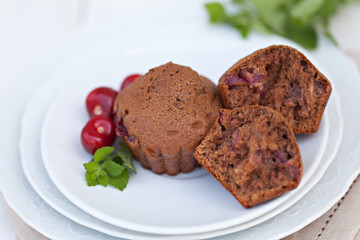 Fototapeta na wymiar Chocolate muffins with ripe cherries