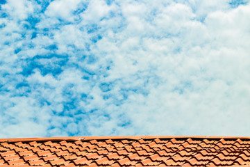 Red roof with a cloudy blue sky on top