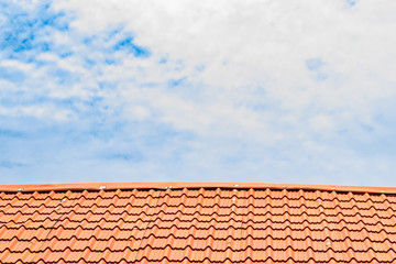 Red roof with a cloudy blue sky on top