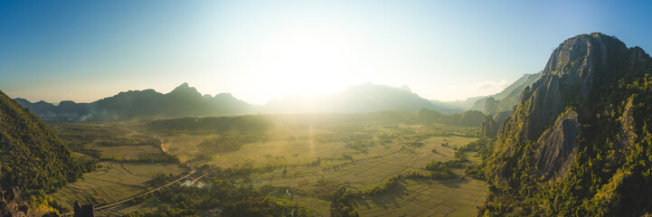 Panoramic view of farm fields and rock formations in Vang Vieng, Laos. Vang Vieng is a popular...