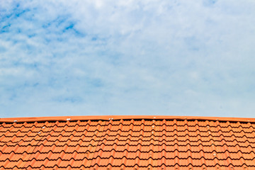 Red roof with a cloudy blue sky on top