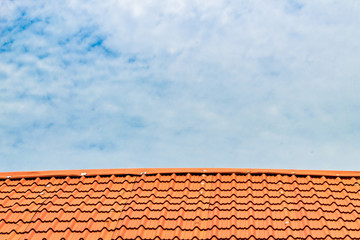 Red roof with a cloudy blue sky on top