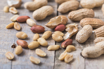 Peanuts scattered on natural wooden desk.