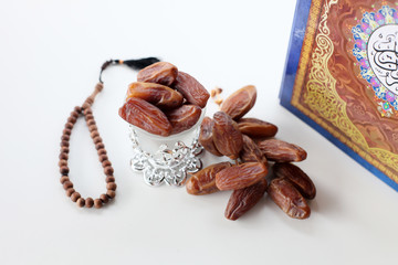 Ramadan kereem with holy quran, dates and rosary isolated on white background
