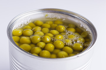 Canned green peas in a iron can on white background